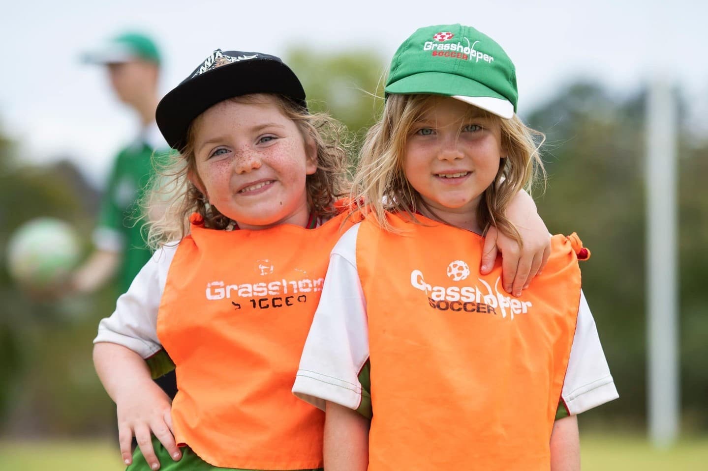 Two girls smiling during a Grasshopper Soccer session